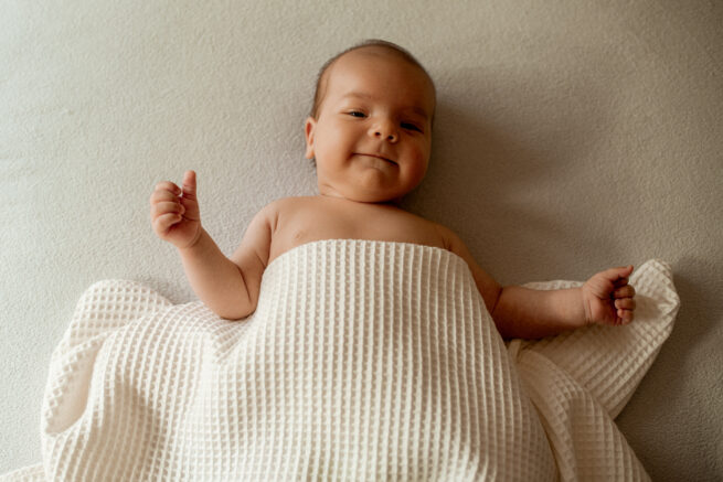 Zestaw prezentowy dla niemowlęcia: otulacz z bawełny w haftowane kwiaty biały, kocyk niemowlęcy bawełniany wafelkowy w kolorze śmietankowym